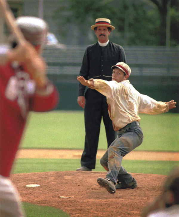 Vintage baseball photo: June 12, 1998: Eric &ldquo;Express&rdquo; Miklich pitching for the Brooklyn Atlantics (NY) in an 1887 match against the Glen Head Zig Zags (NY) on Doubleday Field in Cooperstown, New York.  The Umpire, Gary Monti, is stationed behind the pitcher allowing him a better view to call plays occurring at the bases.  This practice was first instituted by one of the best 19th century umpires, former player &ldquo;Honest&rdquo; John Gaffney.  On April 18, 1888, opening day of the American Association season, Gaffney called balls and strikes from behind the pitcher while runners were on base and stood behind the catcher when there were no men on base. Photo by Tom Ferrara.  Click photo to return to previous page.